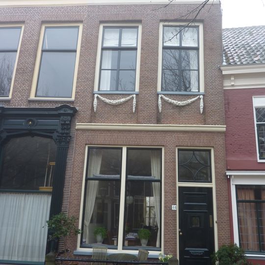 Pand met gevel met rechte kroonlijst en pilasters. De gevel vormt een geheel met nr 42. Guirlandes onder de ramen