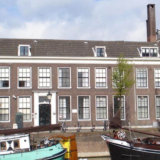 Pand met verdieping, ter breedte van negen vensterassen. Lodewijk XV-ingangspartij; venster met 12-ruits-ramen