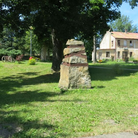 Plastika z kamene a kovu v parku na náměstí Jana Švermy v Kovářské