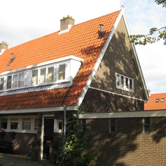 Blok met 8 keukenwoningen, zo genoemd vanwege destijds nieuwe plaatsing van keuken aan de voorzijde, aan de zijkant een houten topgevel, bouwstijl Amsterdamse School.