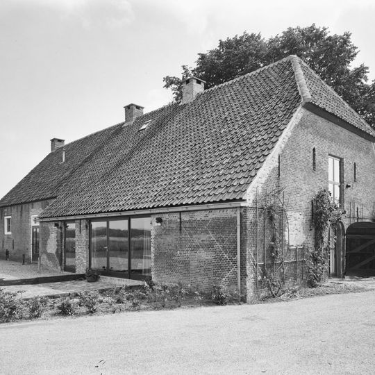 Boerderij van het Brabantse langgeveltype. Woongedeelte onder met riet gedekt zadeldak tegen een puntgevel met rookkanaal in de as. Stal met getoogde inrijpoort en met pannen gedekt wolfdak.
