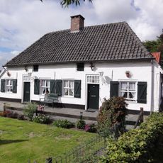 Twee gepleisterde landarbeidershuisjes onder een pannen wolfsdak