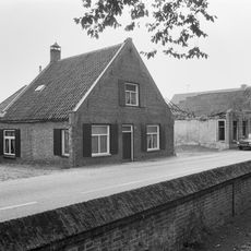 Huis van het langstraatse dorpswoningtype met topgevel bekroond door trappen en toppilaster