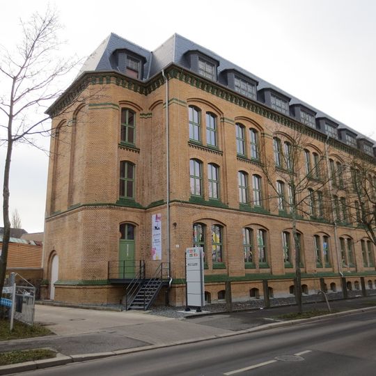 Fabrikkomplex mit dreigeschossigem Kopfbau und dem gleichzeitig errichteten Teil der rückwärtig anschließenden eingeschossigen Oberlichthalle Waldenburger Straße 63