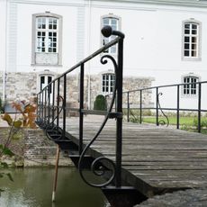 Meerssenhoven Castle: behind the house is a 19th-century bridge over the canal with a simple iron railing with curled supports