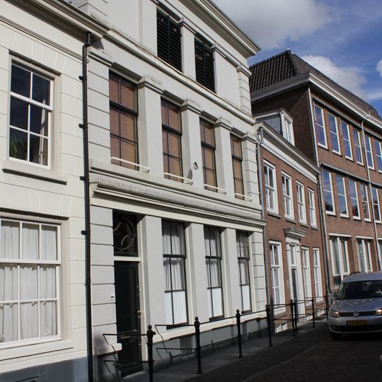 Pand met gepleisterde pilastergevel. Mansardedak