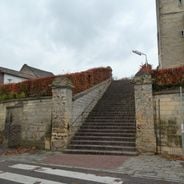 Retaining wall with brick staircase and four fence pillars as well as fence with fence pillars near Sint-Mauritiuskerk