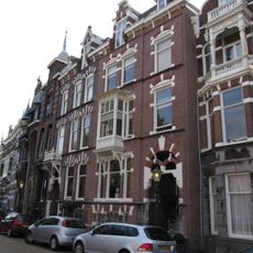 Pand in neo-renaissance trant. Gevel versierd met banden en negblokken. Souterrain. Rechts getoogde ingangspartij.