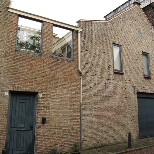 Pand bestaande uit twee puntgevels met vlechtingen en geprofileerd natuurstenen zij-afdekstukken