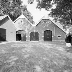 Dubbele schuur opgemetseld in rode baksteen onder een dubbel zadeldak grijze hollandse pannen