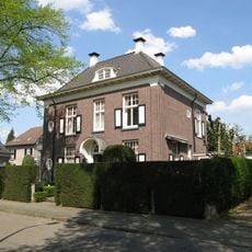 Blokvormige tweelaags villa met kolommen langs de straat