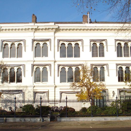 Onderdeel van een reeks herenhuizen aan de Westerkade een gepleisterde gevelwand in de trant van Rose. Aan de Javastraat eenvoudige lijstgevel