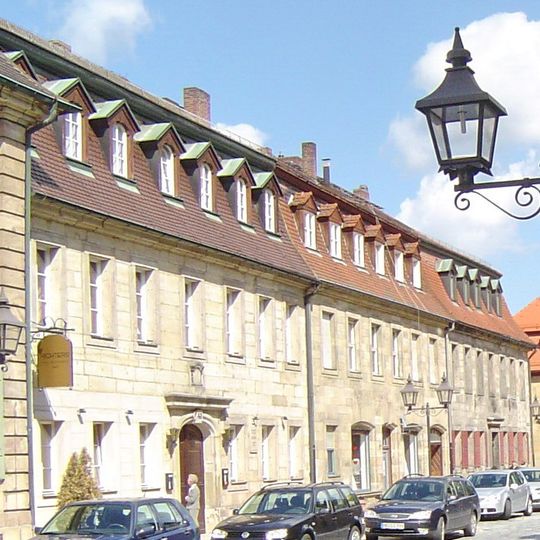 Geschlossene Reihe von drei Sandsteinquaderhäusern mit Mansarddach