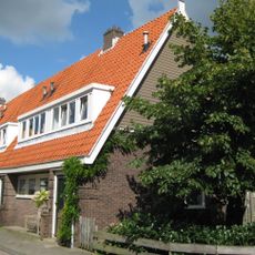 Blok met 6 keukenwoningen, zo genoemd vanwege destijds nieuwe plaatsing van keuken aan de voorzijde, aan de zijkant een houten topgevel, bouwstijl Amsterdamse School.