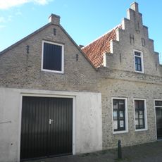 Pandje onder zadeldak tussen gepleisterde trapgevel voor en tuitgevel achter