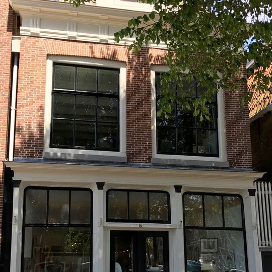 Pand met hoge verdieping en kroonlijst met gesneden consoles onder schilddak met topschoorsteen