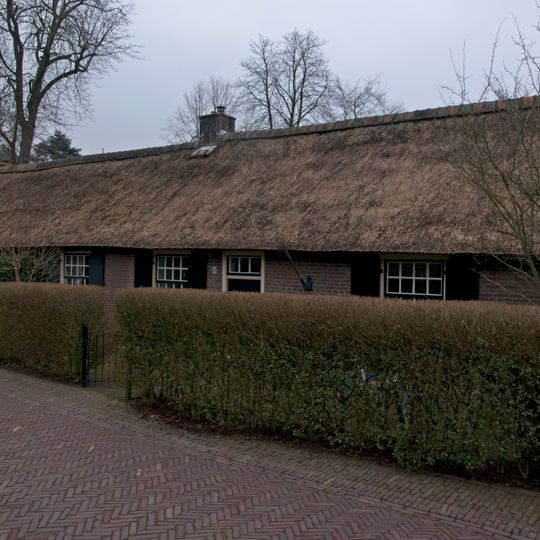 Lage arbeiderswoning onder een rieten zadeldak