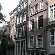 Pand met gevel onder latere rollagentop deur en snijraam