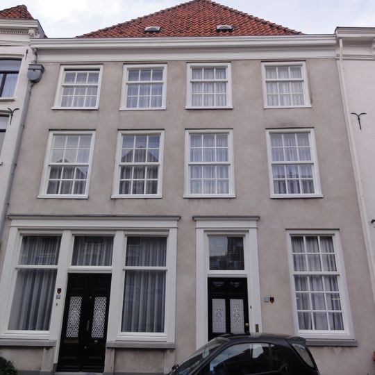 Breed pand onder hoog schilddak en met gepleisterde gevels