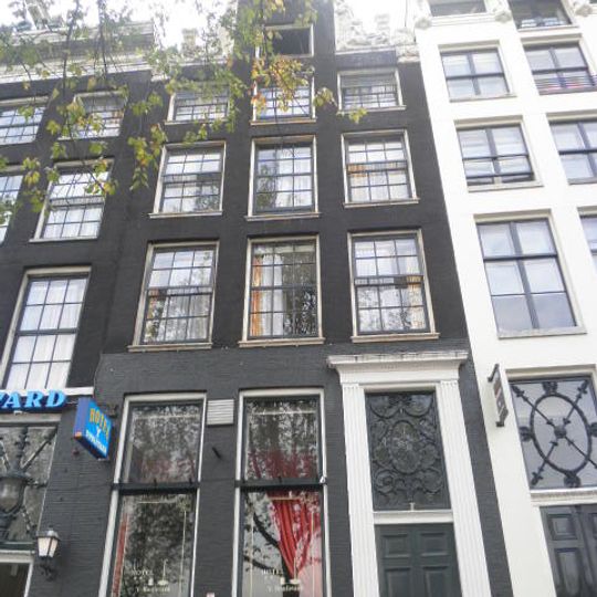 Pand met rijk gebeeldhouwde halsgevel met vleugelstukken van bijzonder ontwerp en met versierde stoep