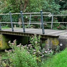 De brug over de wegsloot bestaat uit twee betonnen landhoofden die over de sloot met elkaar zijn verbonden door een samenstelsel van houten planken.