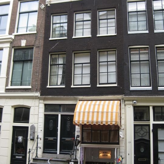 Pand met gevel onder rechte lijst met consoles en met geblokte pui