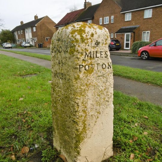 Milestone, Potton Road, in front of service road, 100m S of jct Stratton Way