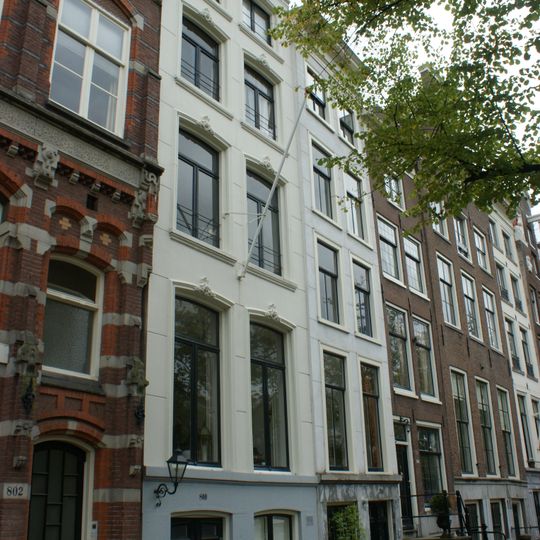 Pand met smalle met gepleisterde gevel onder rechte lijst en voorzien van vensteromlijstingen