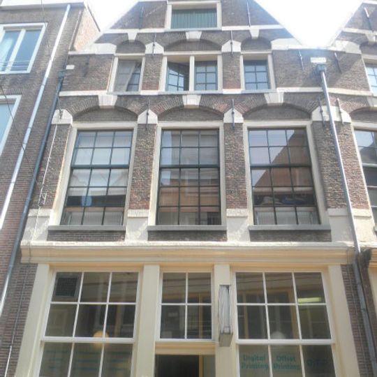 Pand met top puntgevel afgekloofde trapgevel met grote boogblokken als versiering