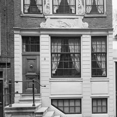 Pand met halsgevel van het 'type-met-doorboorde-bloem' en palmet in de afdekking