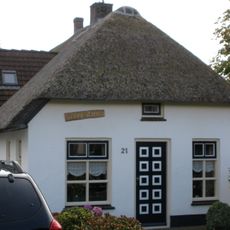 Gepleisterde kleine hoeve onder rieten wolfdak